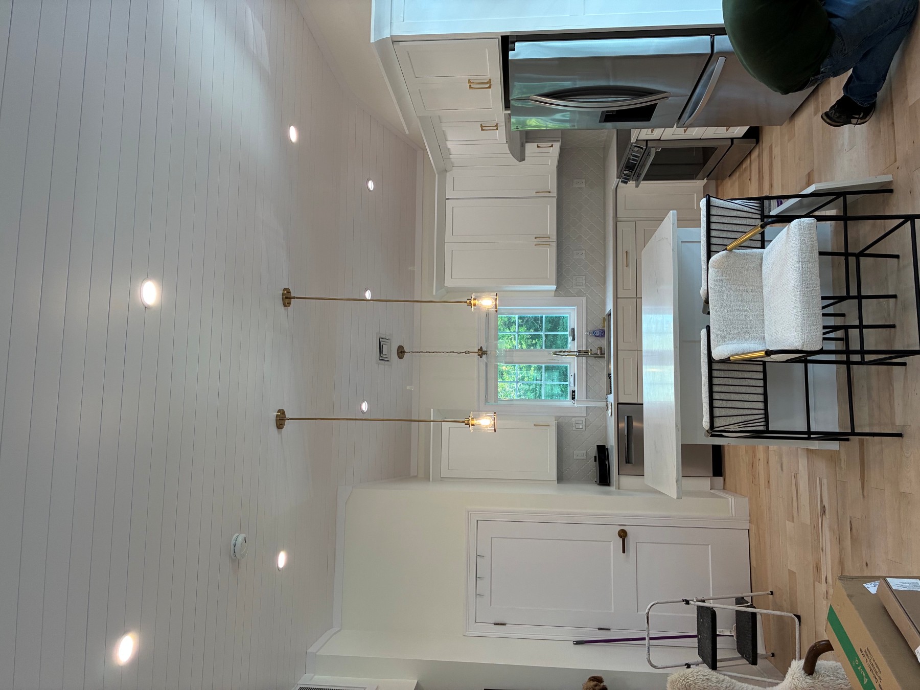 Boston Light & Power electrician installing recessed lighting and island pendants on a vaulted shiplap ceiling in Hingham, MA.