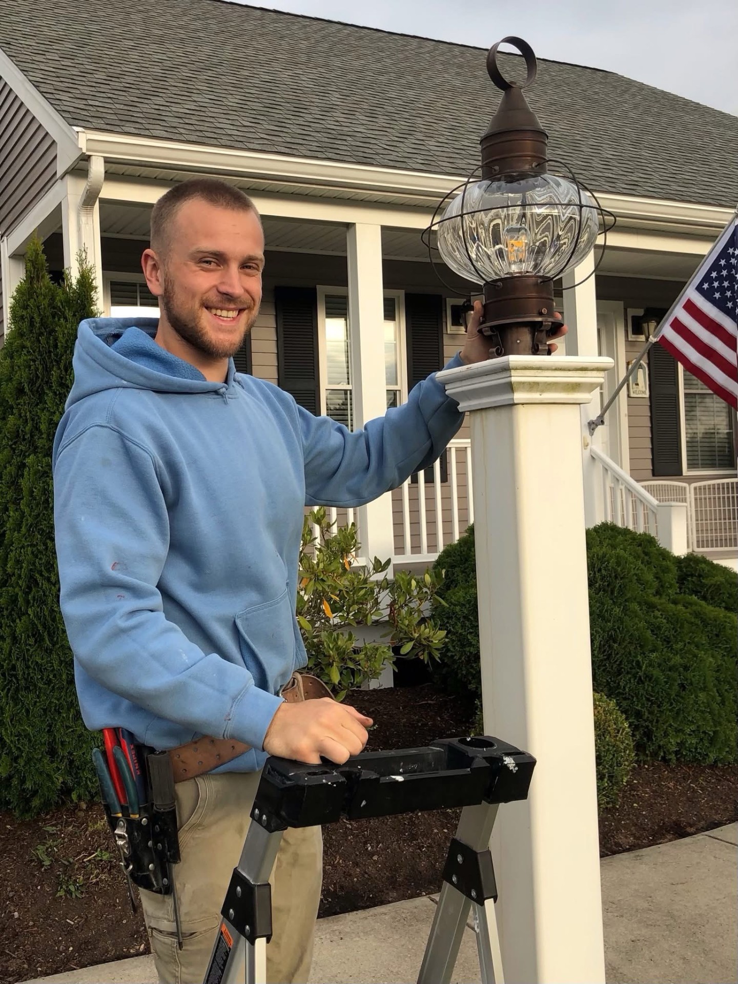 Boston Light & Power electrician installing an exterior lantern in Milton, MA.